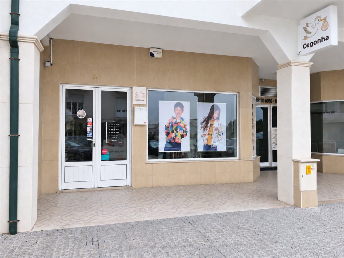 Entrada e montra da loja Cegonha, com o letreiro sobre a porta